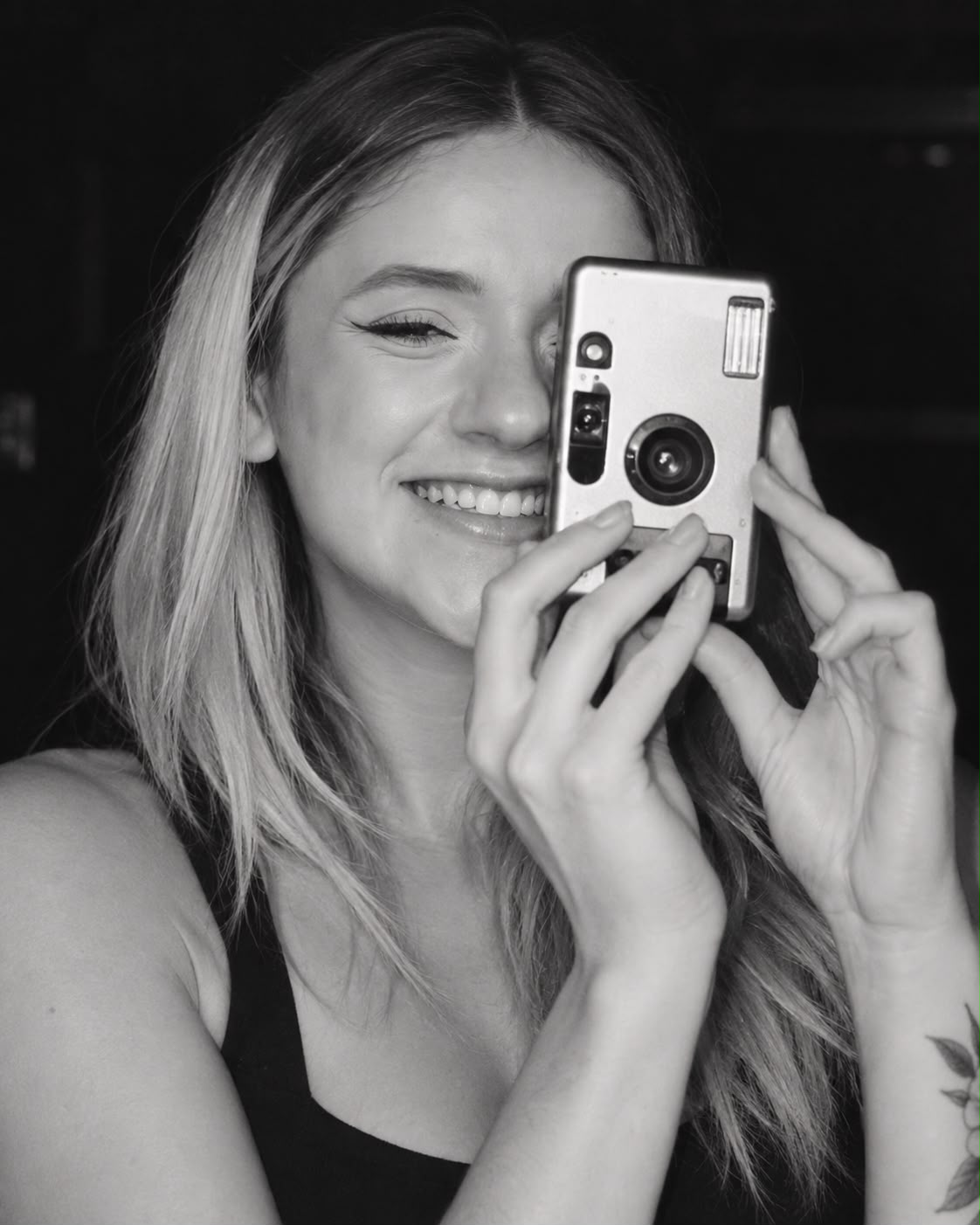 Letícia sorrindo em um retrato em preto e branco